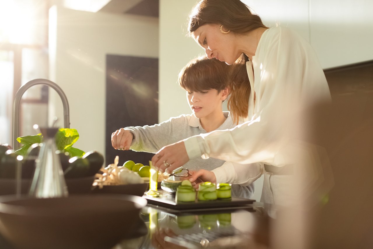 A mother and so preparing food in the kitchen