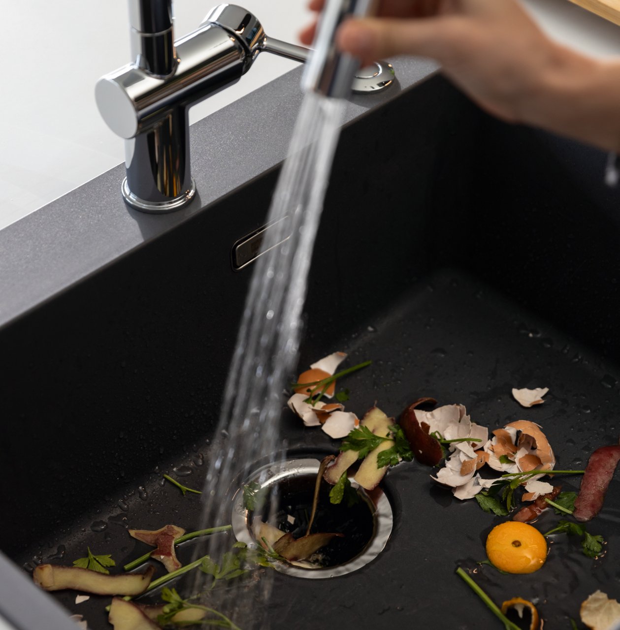 Food waste being rinsed down into a Franke Elite Slimline Waste Disposal Unit