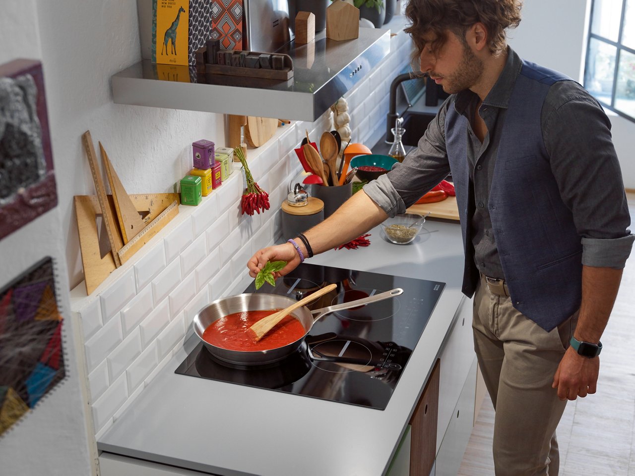 Homme préparant une sauce tomate sur une plaque de cuisson Smart de Franke