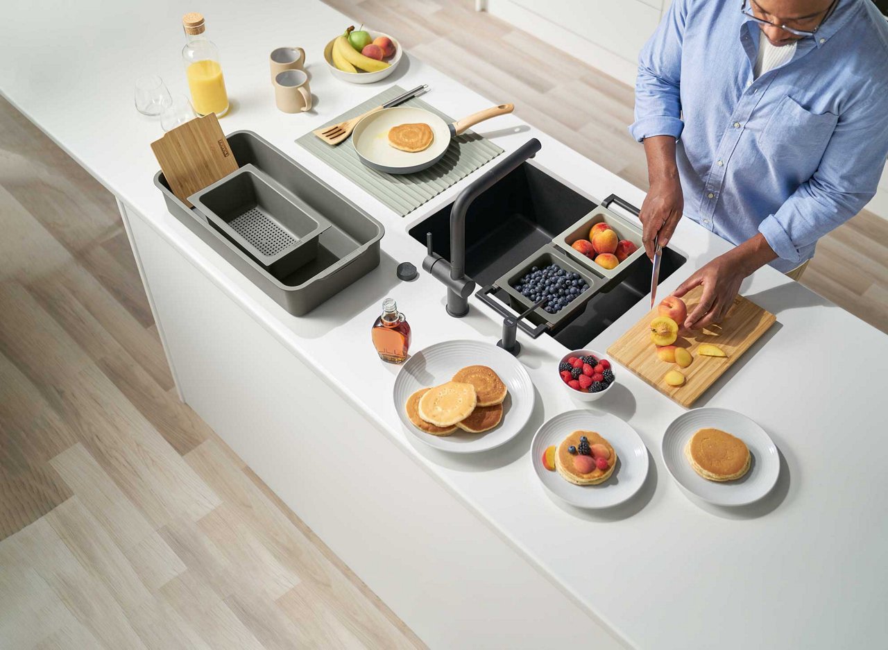 Man cutting various ingredients with Franke All-in Accessories