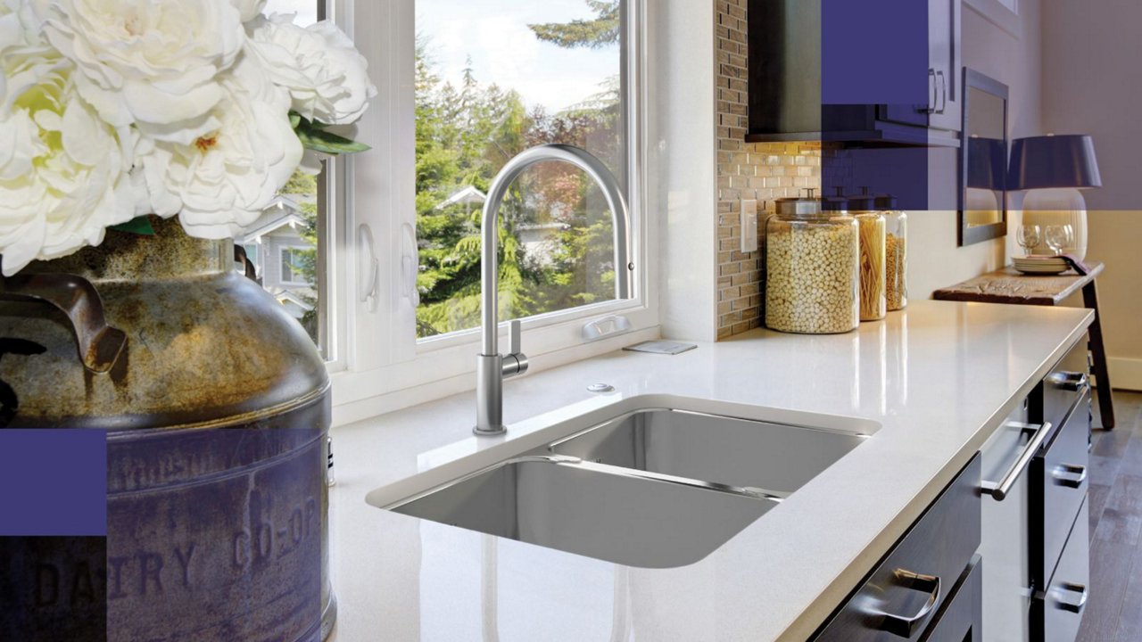 Single bowl undermount kitchen sink and chrome faucet in a moden white kitchen with lime green accents