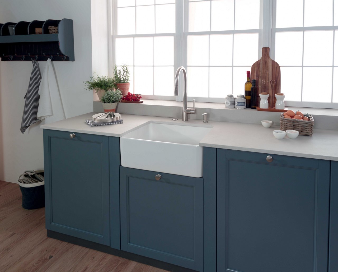 White apron front sink in farmhouse kitchen with blue cabinets