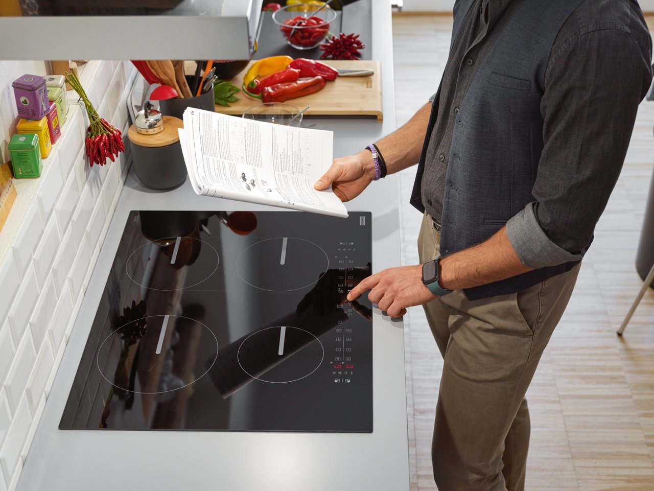 Man reading instruction manual of an induction hob