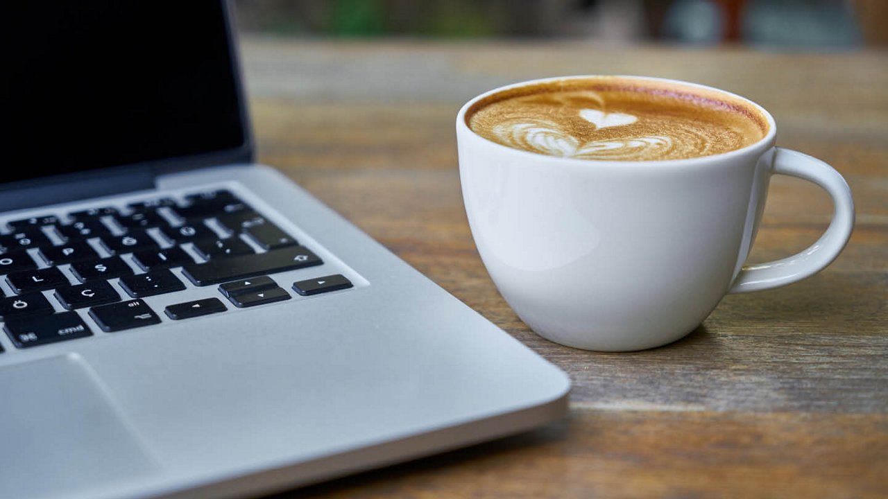 Franke Coffee Systems, Laptop and cup of coffee on wooden table