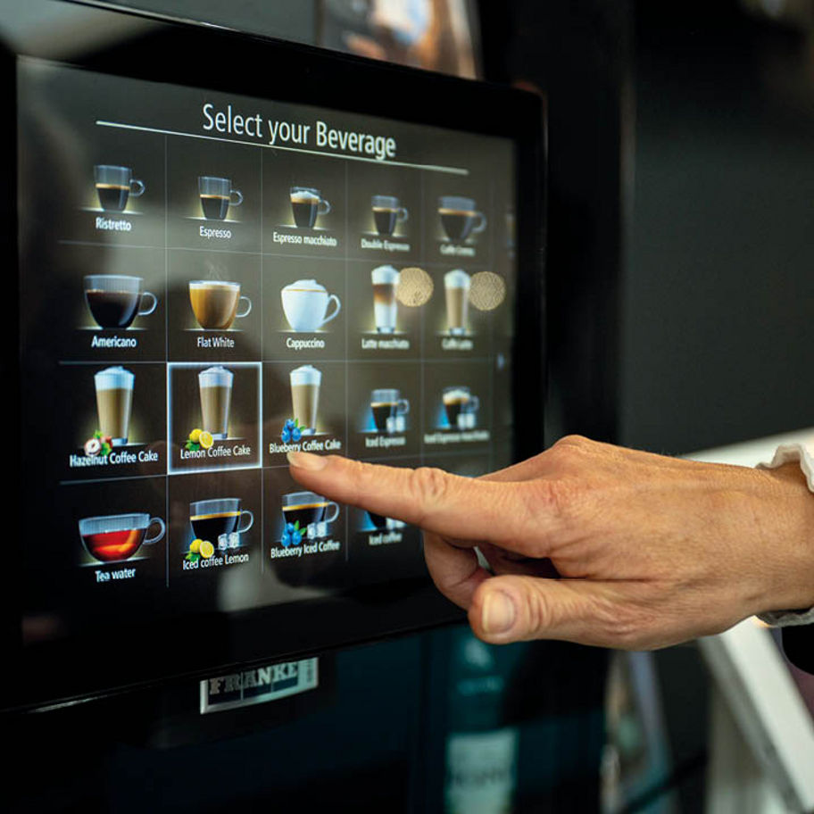 Franke Coffee Systems, fully automatic coffee machine Franke, touchscreen with beverage menu, hand selecting beverage