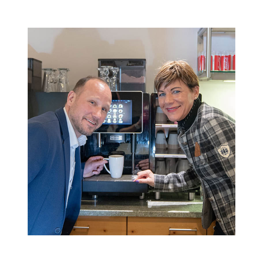 Franke Coffee Systems 2 people standing in front of fully automatic coffee machine Franke, grabbing coffee