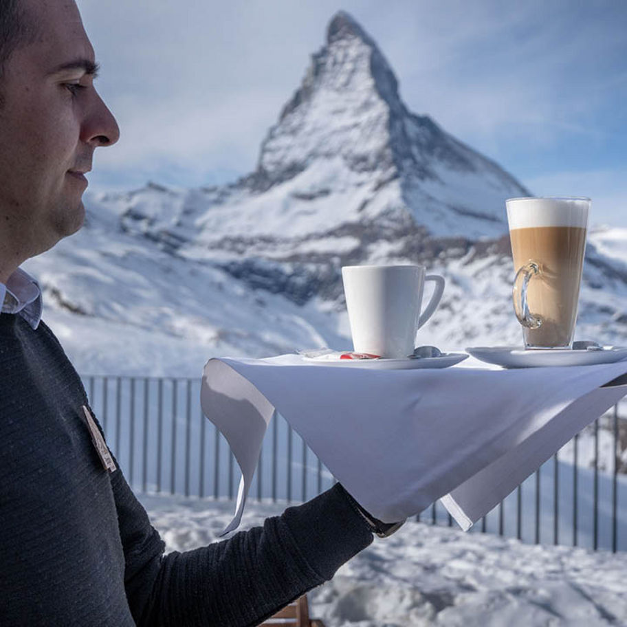 Franke Coffee Systems waiter carrying tray with coffee beverages in front of Matterhorn