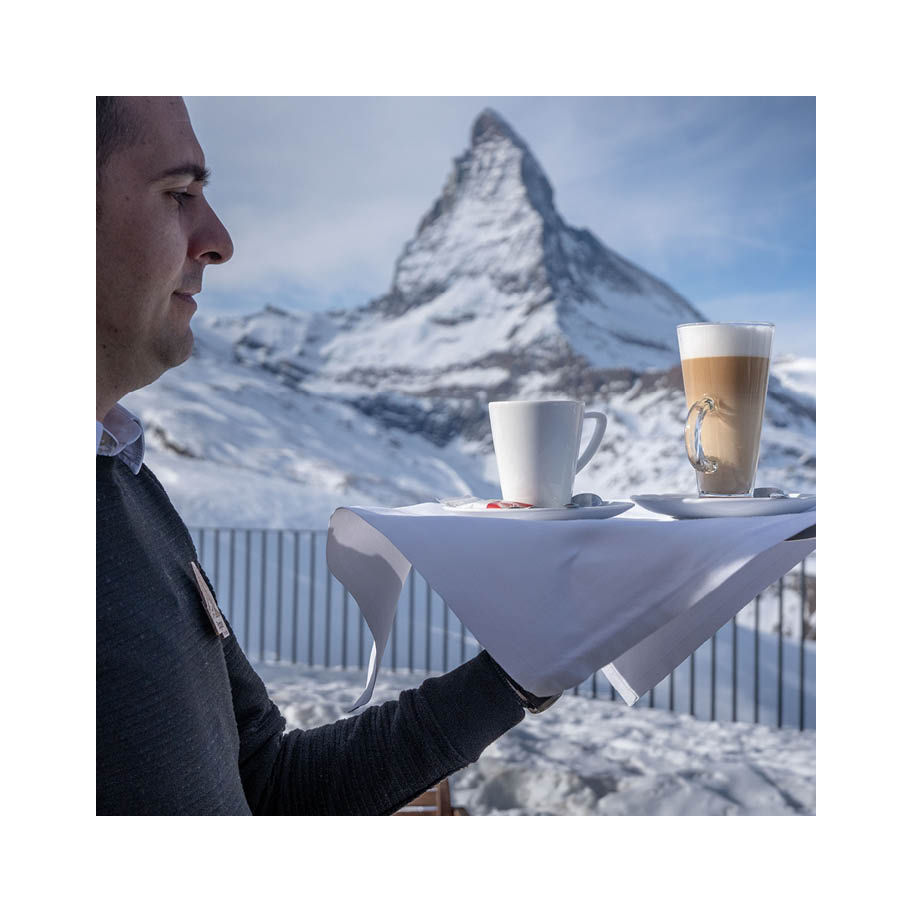 Franke Coffee Systems waiter carrying tray with coffee beverages in front of Matterhorn