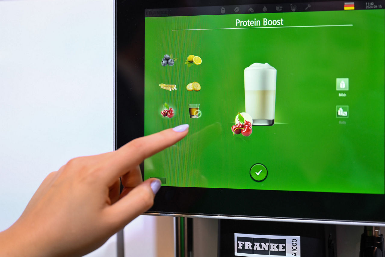 Person choosing a protein infused coffee drink from a coffee machine