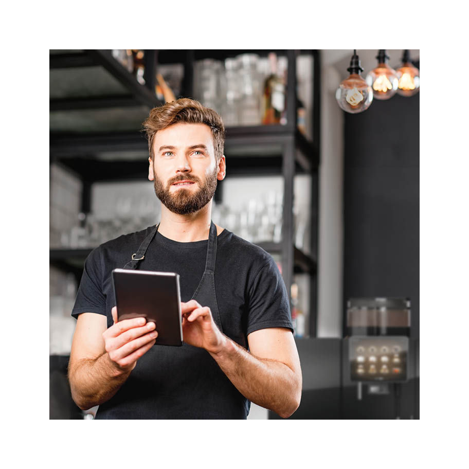 Franke Coffee Systems, waiter holding tablet, fully automatic coffee machine Franke in the background