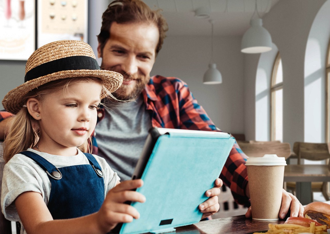 Franke Coffee Systems, family, man with coffee cup, young girl with tablet, sitting at the table in quick service restaurant