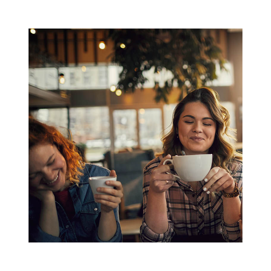 Franke Coffee Systems women drinking coffee in café, light atomosphere