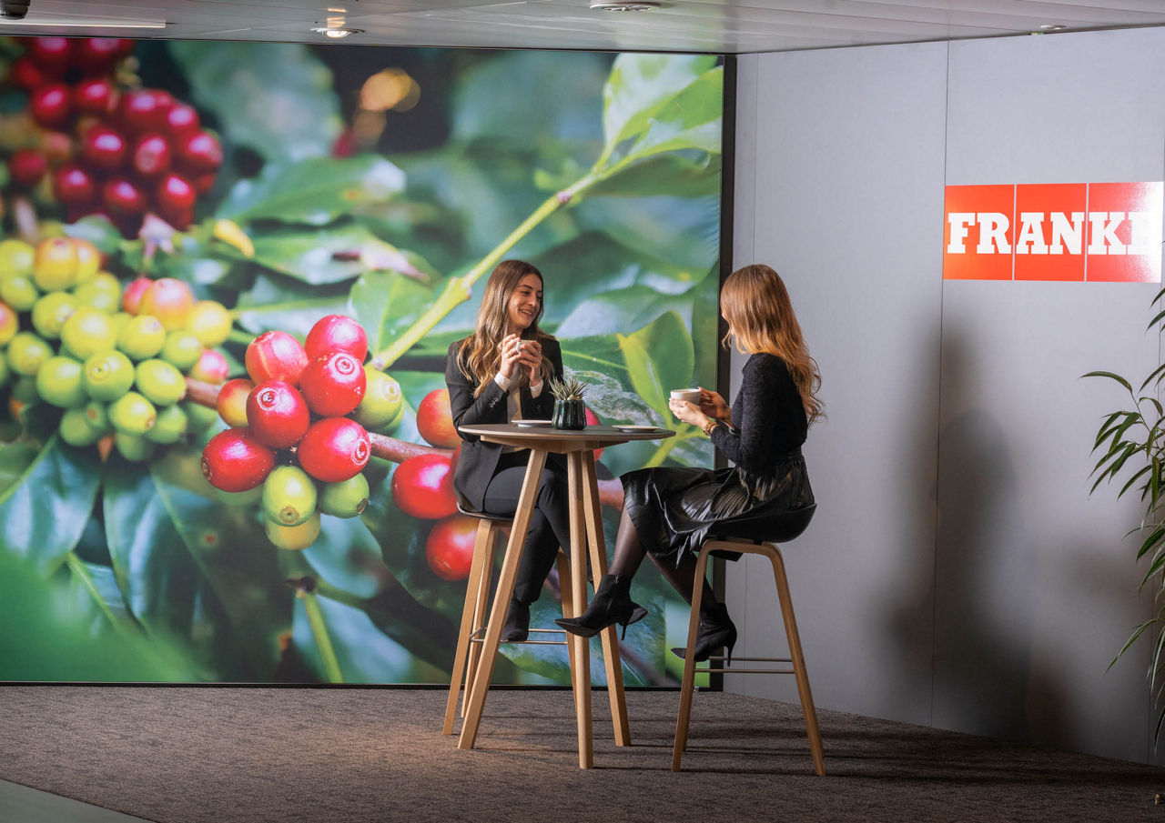 Franke Coffee Systems, Aarburg, Showroom, two women sitting on high table chatting and drinking coffee