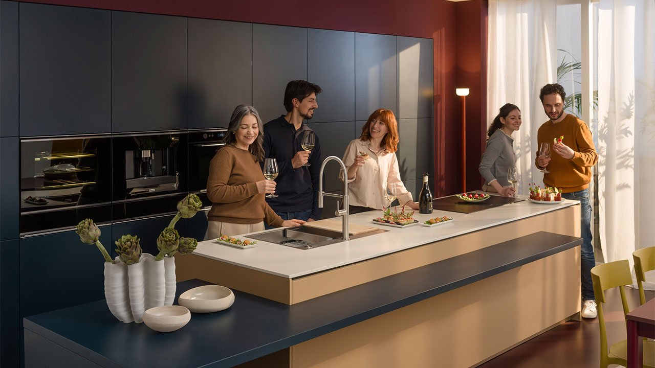 Family gathered in the kitchen using Franke kitchen products