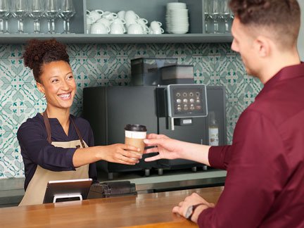 Restaurant employee handing out a cup of coffee to a customer