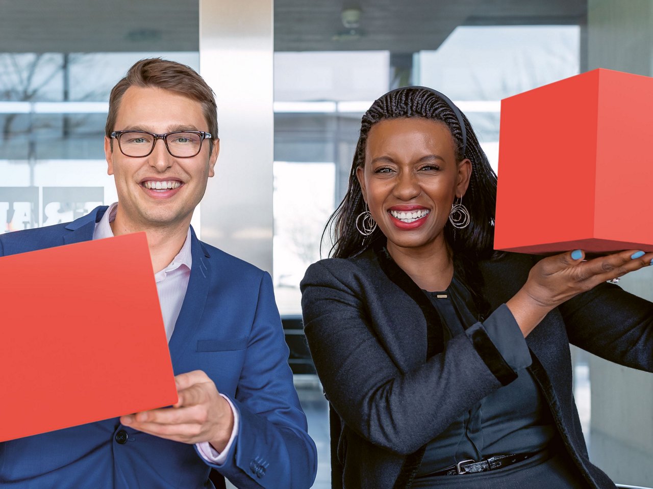 two people holding up red cubes