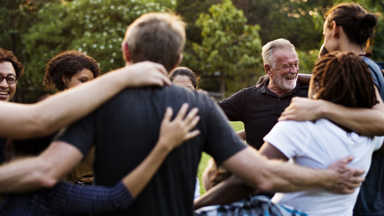 group of people standing in a circle in a park