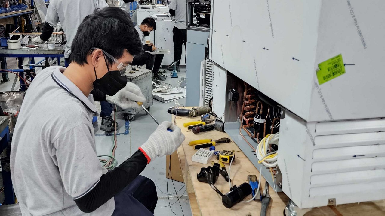 young electrical engineering technician assembling a machine