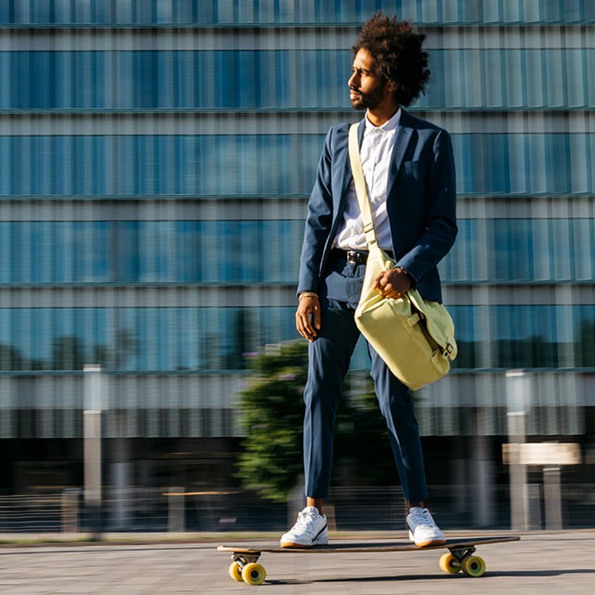 Sustainability represend by a person cruising on a longboard in front of a  modern building