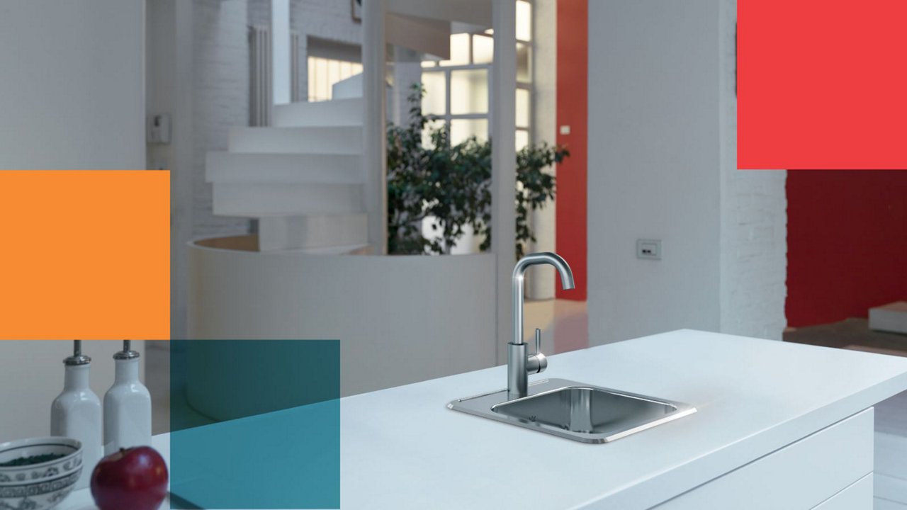 Mediterranean style kitchen with a white kitchen island featuring a stainless steel prep sink and prep faucet