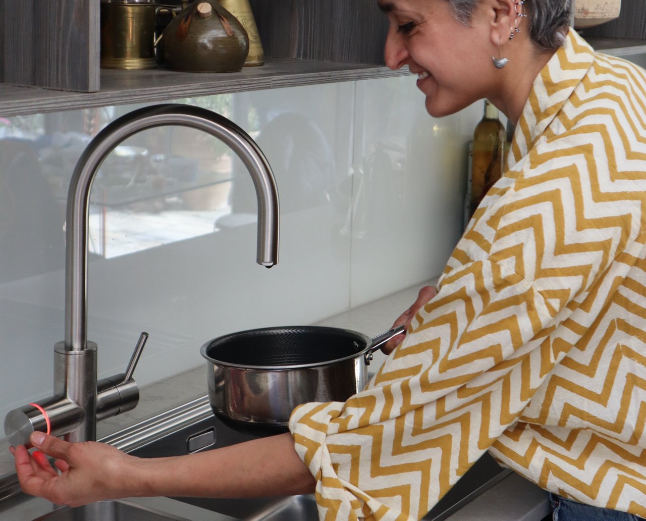 Chetna using the Mythos Water Hub tap in the Franke kitchen