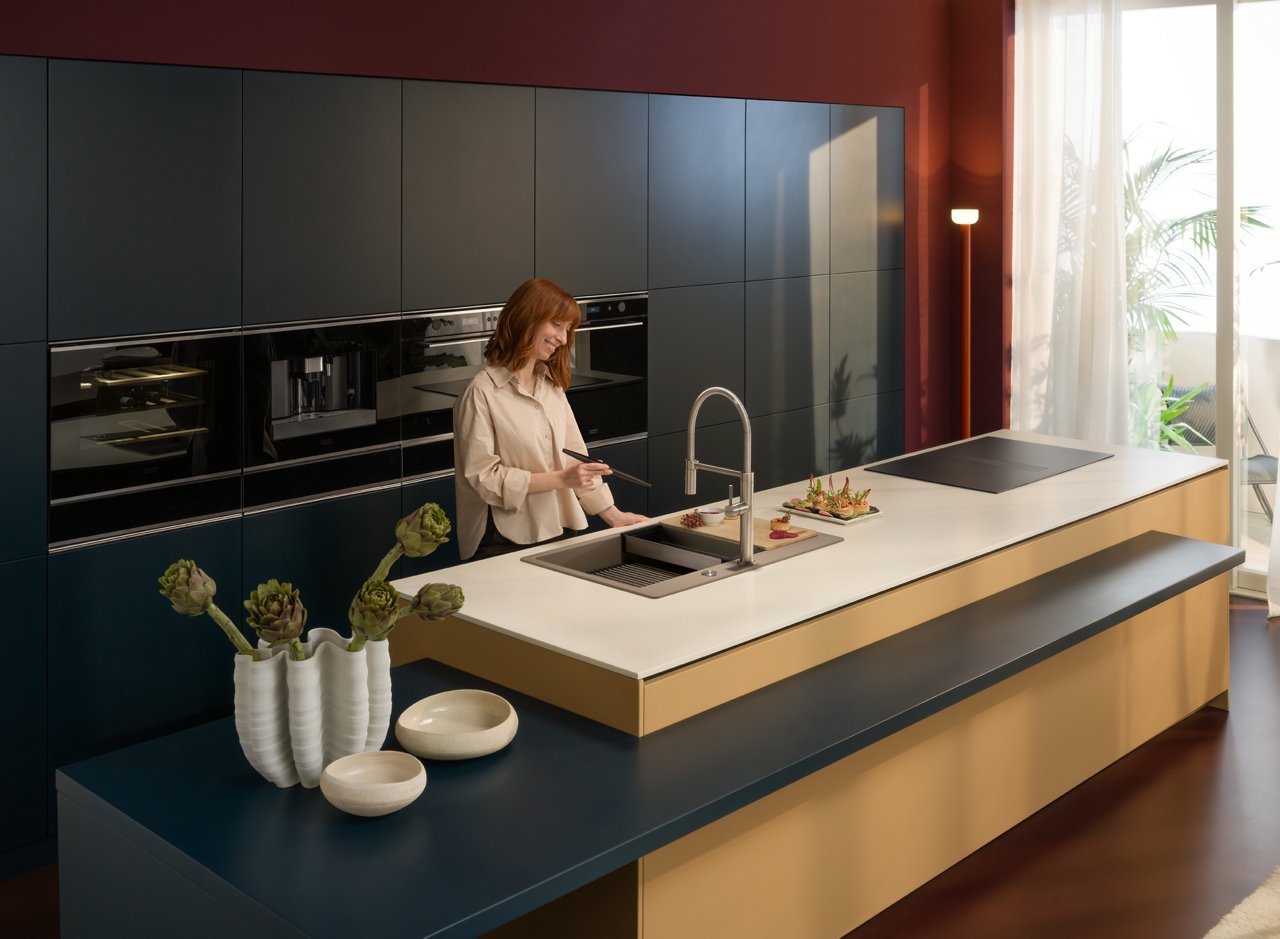 Donna in una cucina completa di prodotti Franke