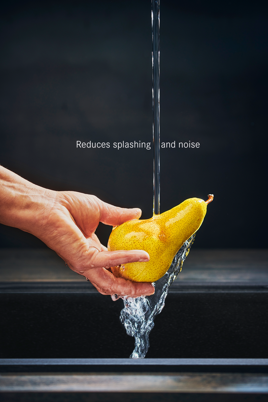 Man Holding a pear under a laminar jet to showcase the splash reduction effect