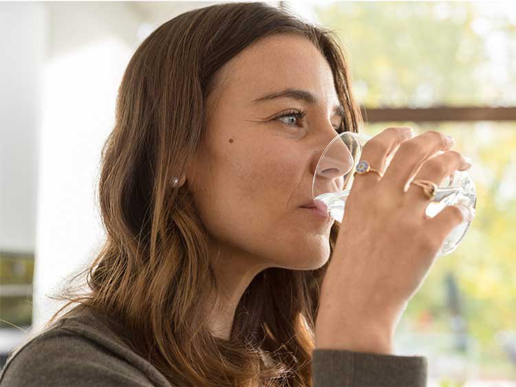 woman drinking filtered water from a glass