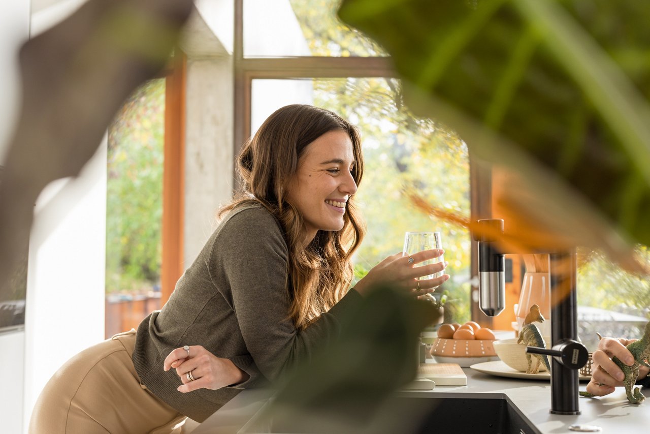 Woman drinking a glass of water from a Vital tap