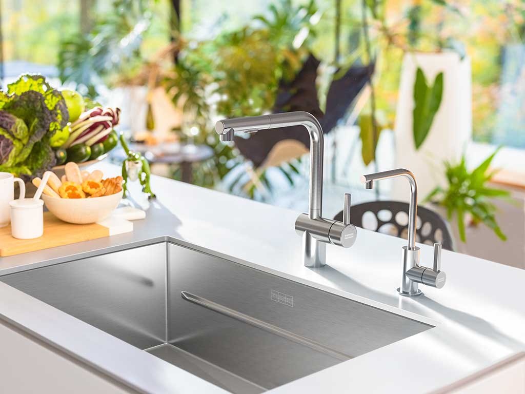 Bright kitchen with an island featuring a stainless steel sink, Pull out stainless steel faucet and coordinating cold water dispenser