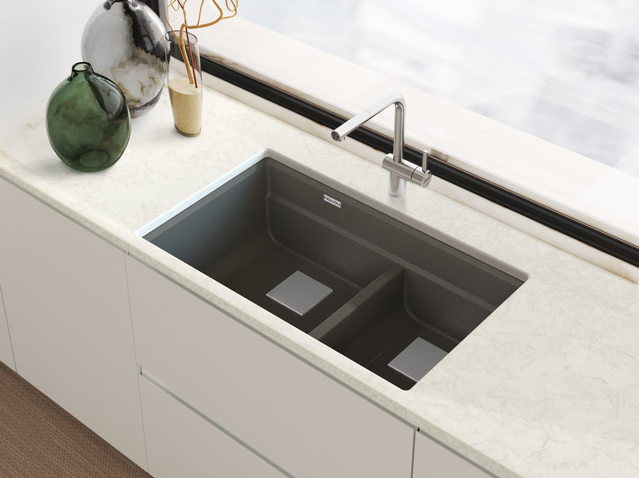 Modern Franke Peak double-bowl granite kitchen sink with stainless steel faucet in a white marble countertop.
