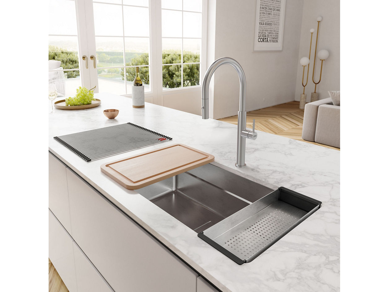 Franke Stainless Steel Workcenter Sink with sink accessories over the sink being used to prep food. 