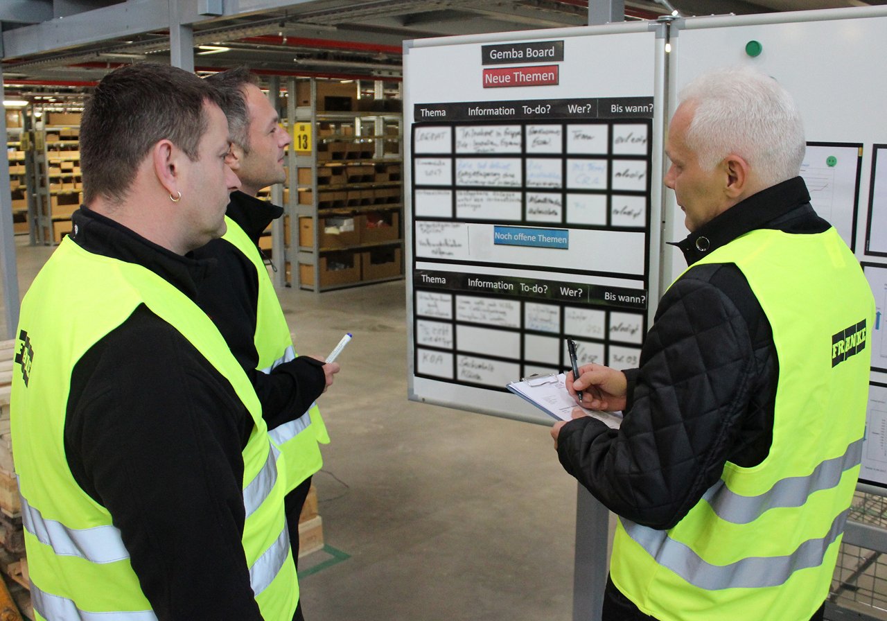 Logistics team reviews a planning board for a day's outbound shipments from a Franke distribution center