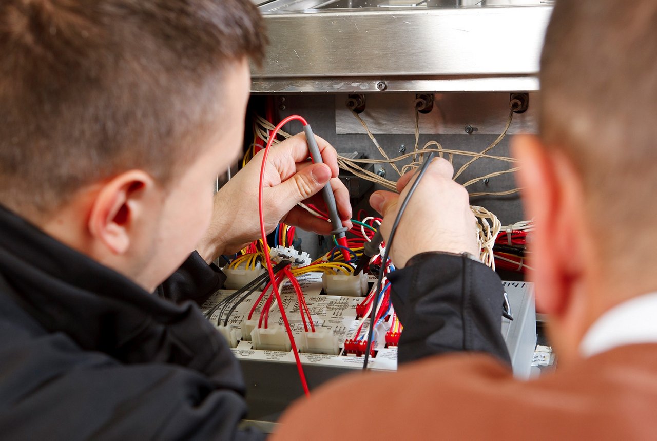 Franke technician trains a new employee on electrical test procedures for foodservice equipment