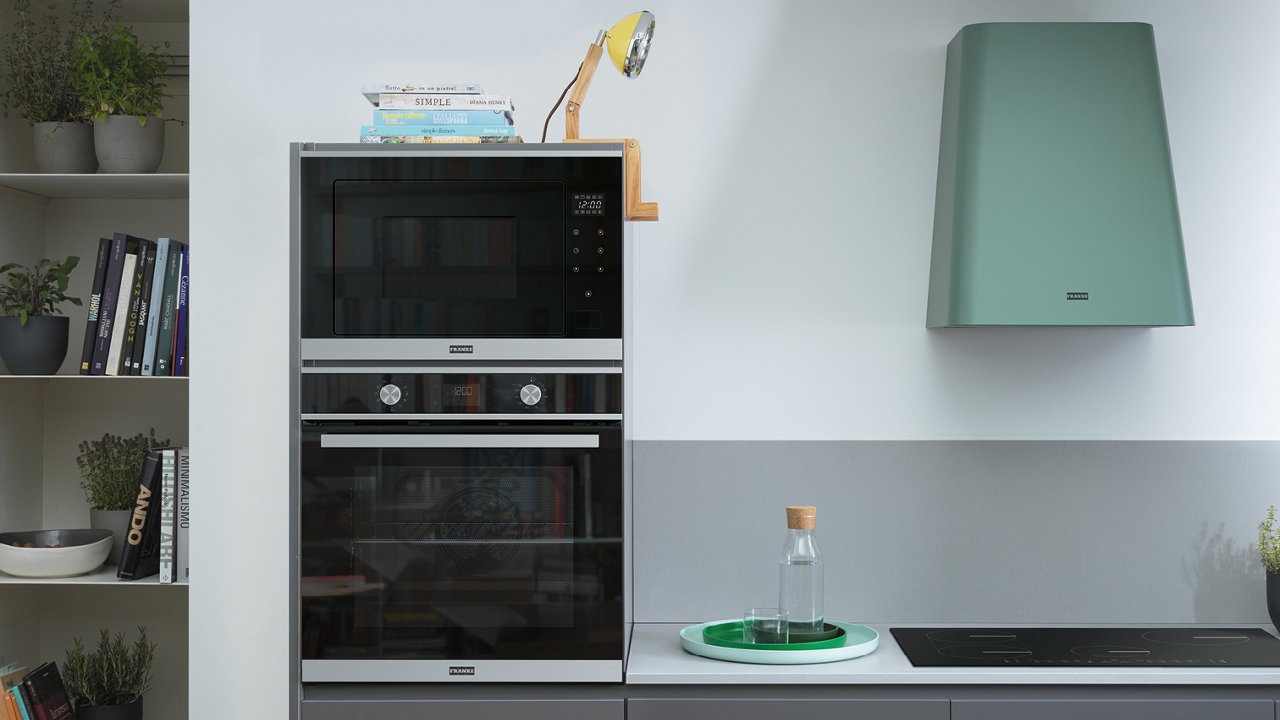 Cocina con tonos blancos y marrones y una columna de elecotrodomesticos 