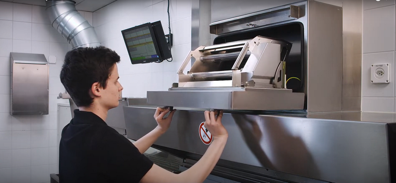 A kitchen worker opens the Franke UVC Gen 5 unit to remove the cleanable cartridge.