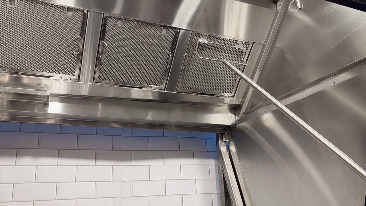 A tool is used to remove one of a row of Franke cascade filters from a canopy exhaust hood