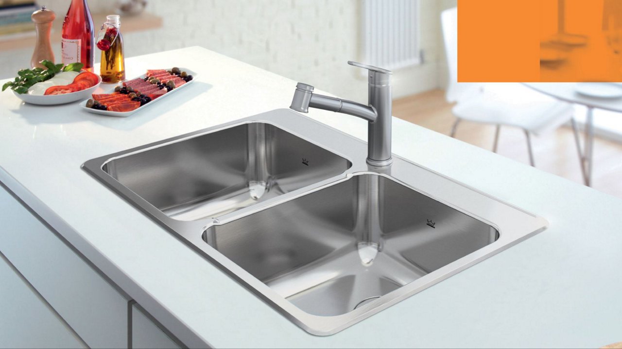 Kitchen island featuring a double bowl stainless steel kitchen sink and chrome pull out faucet