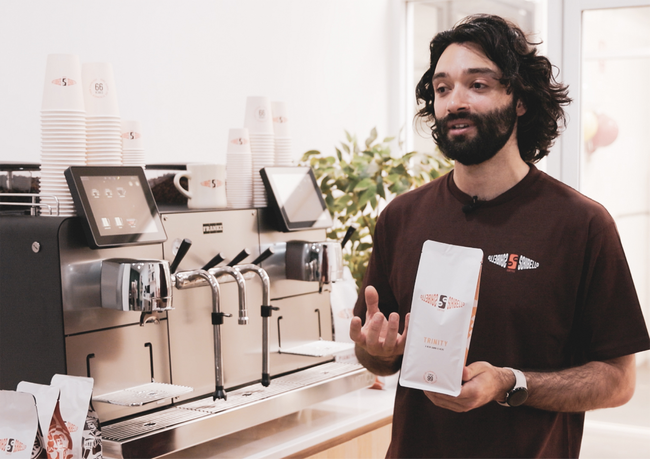 Franke Coffee Systems, Schibello Coffee, Mytico, Matt Annetta, barista man talking in front of the coffee machine and holding a coffee bag