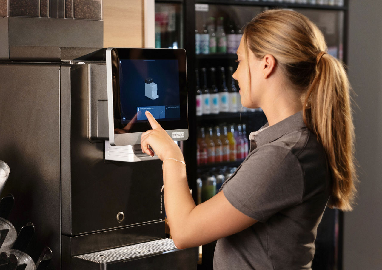 Woman cleaning the coffee machine
