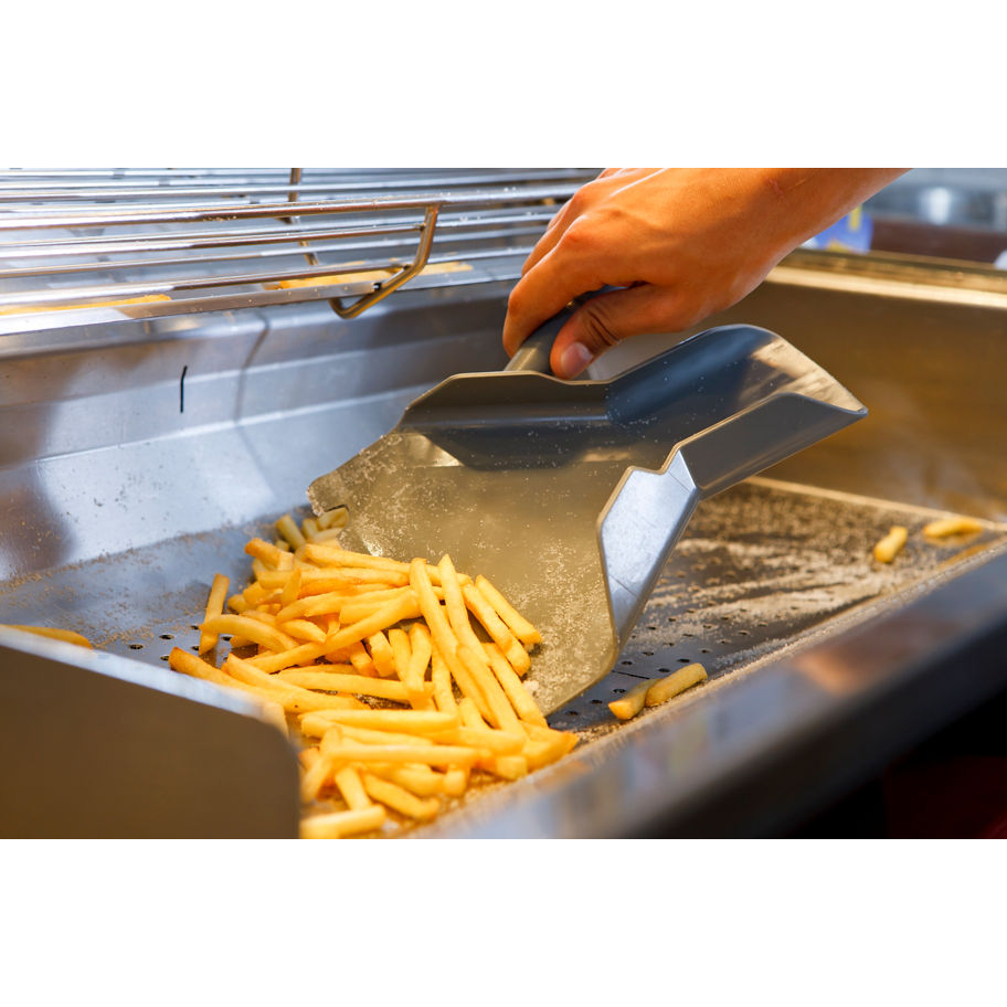 Close up of a person's hand using a scoop to portion hot french fries