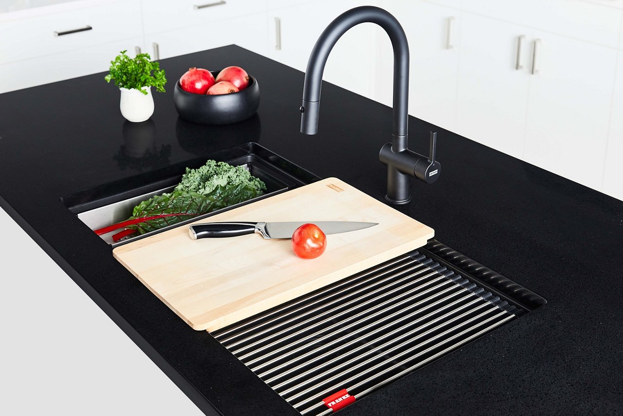 Vegetables being prepped on sink accessories  over a Franke Maris granite sink 