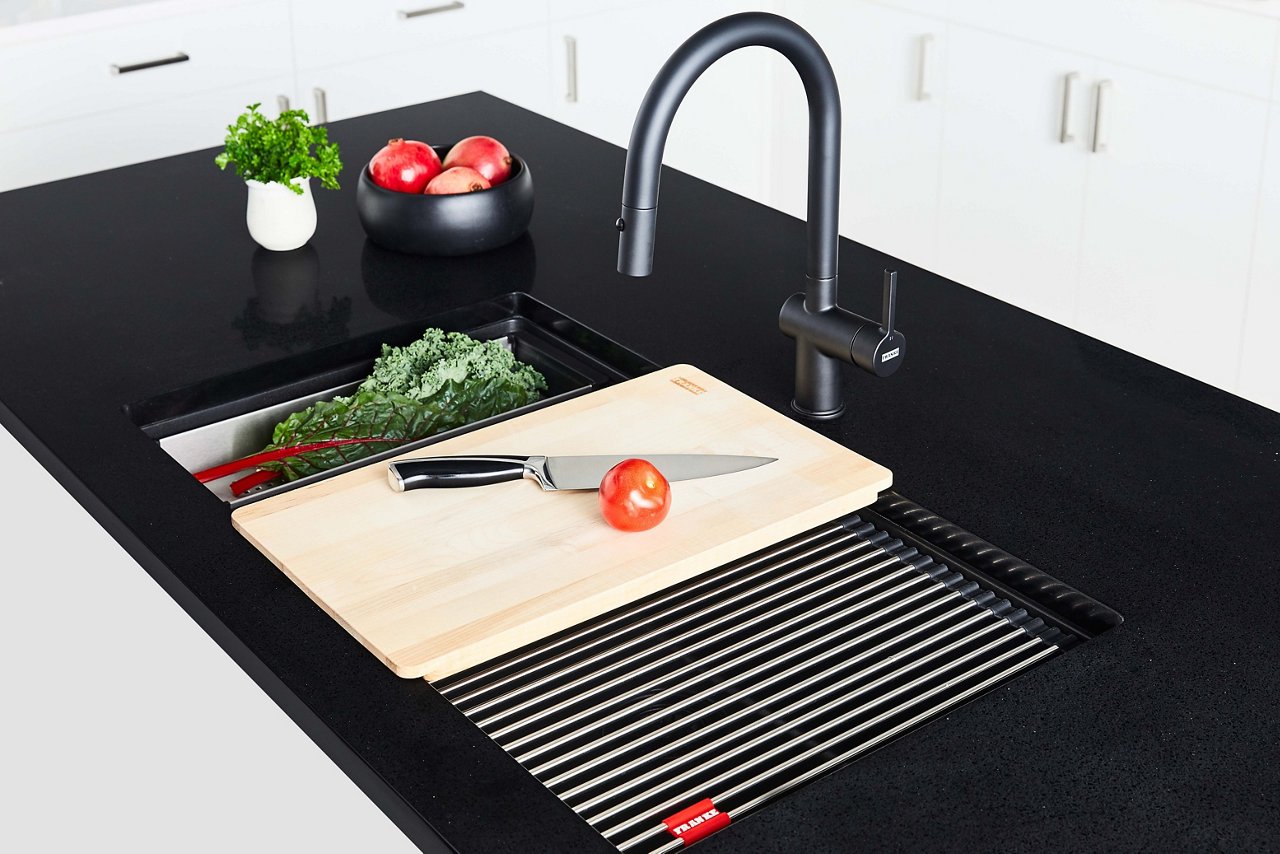 Black kitchen coutntertop with Matte Black Maris granite kitchen sink featuring sink accessories paired with a matching Matte Black pull down kitchen faucet 