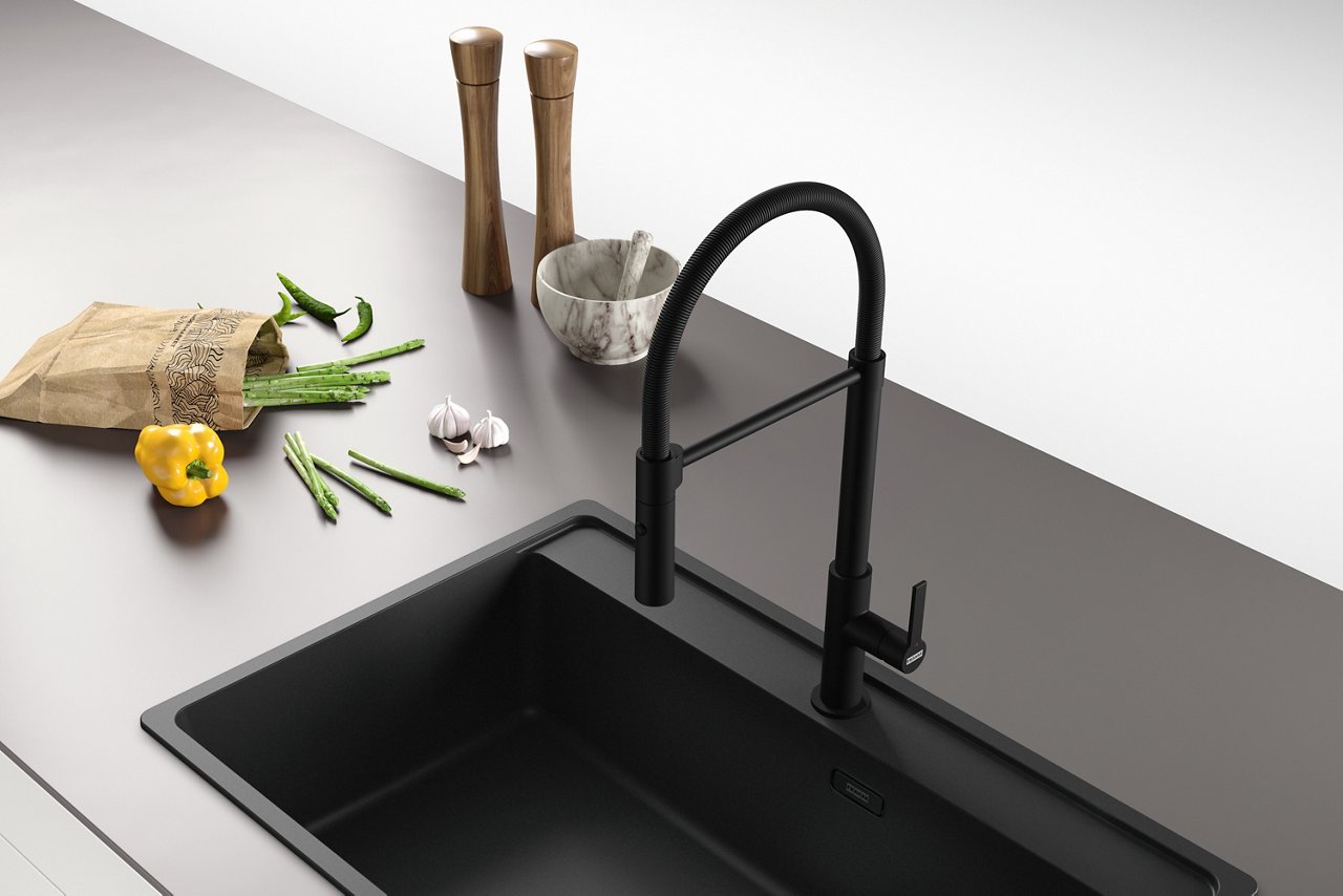 black tap and sink and flowers on counter