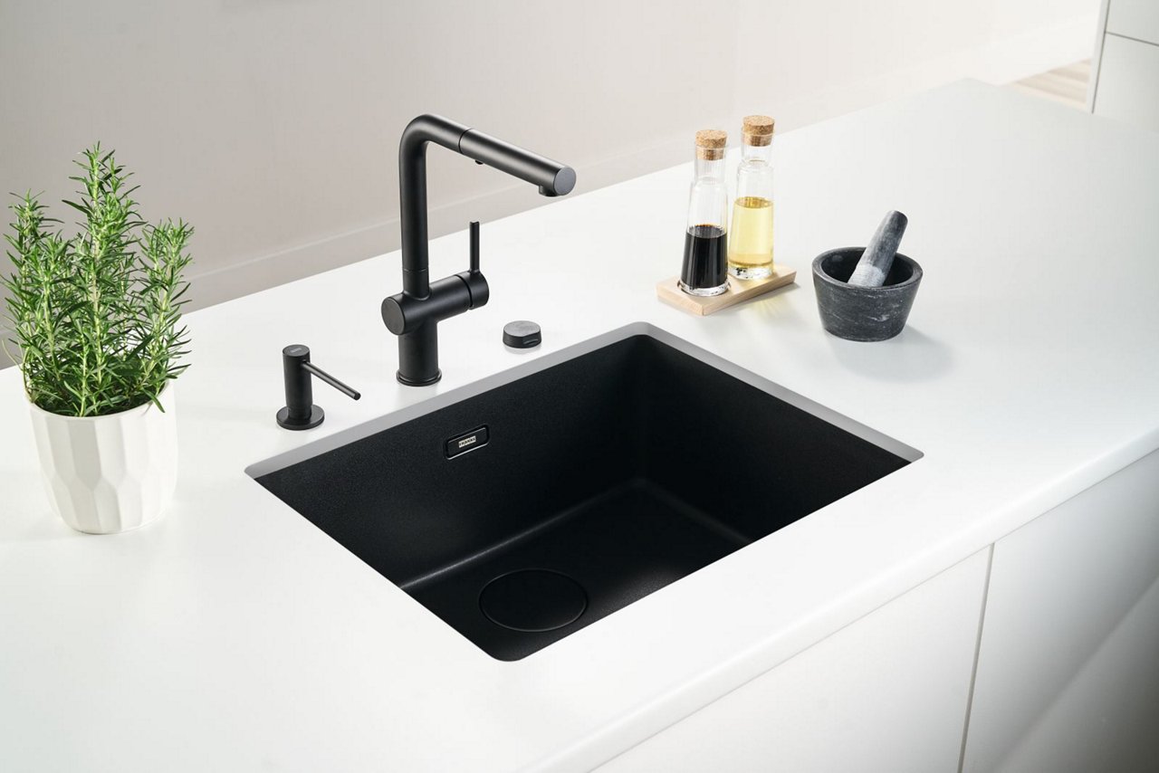 Fregadero y grifo de cocina negro con dispensador negro instalado bajo encimera blanca