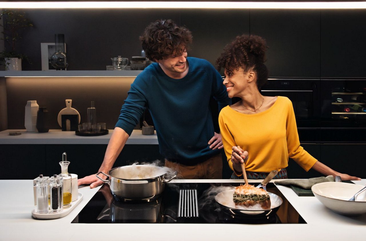 Cocina con tonos blancos y marrones y una columna de elecotrodomesticos 