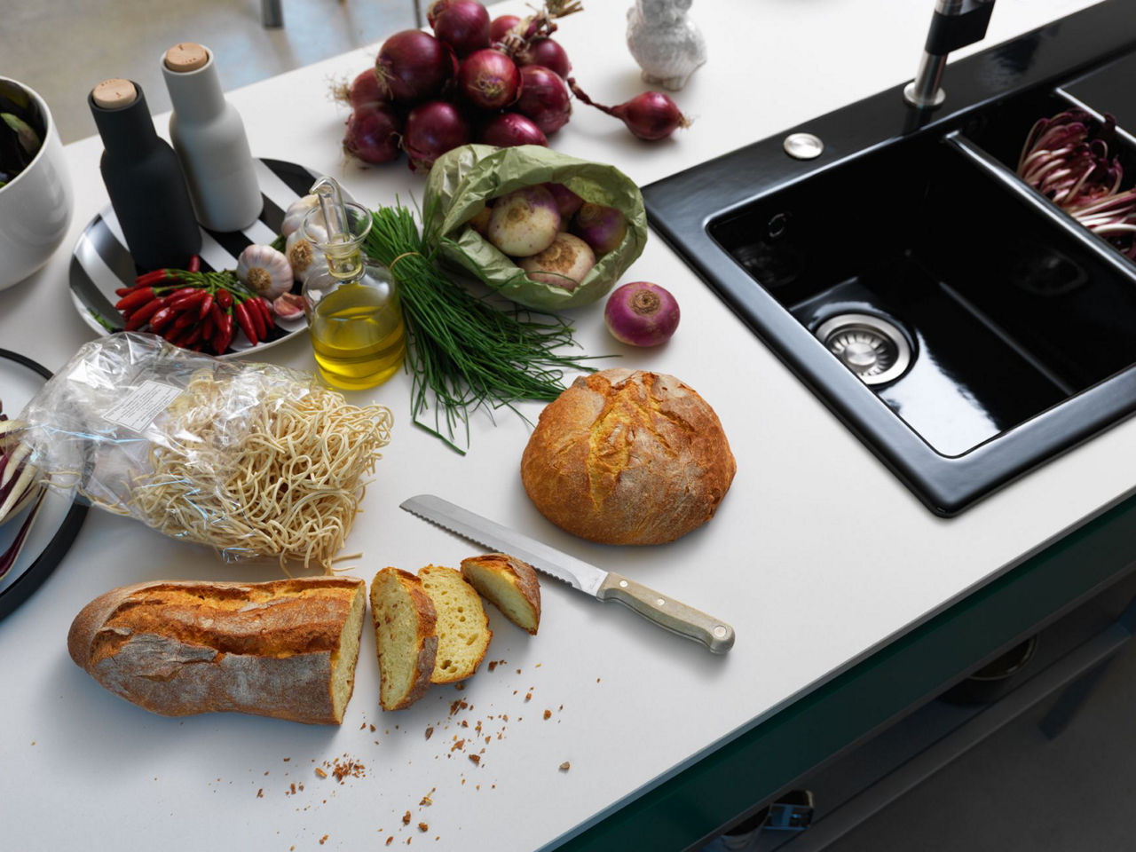 Plan de travail cuisine en blanc avec un évier en céramique noir de Fraceram