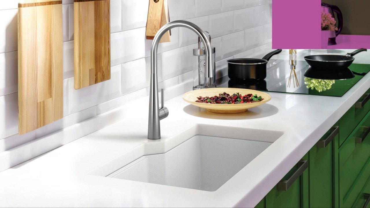 Kindred white granite single bowl undermount kitchen sink paired with a stainless steel faucet in a white countertop