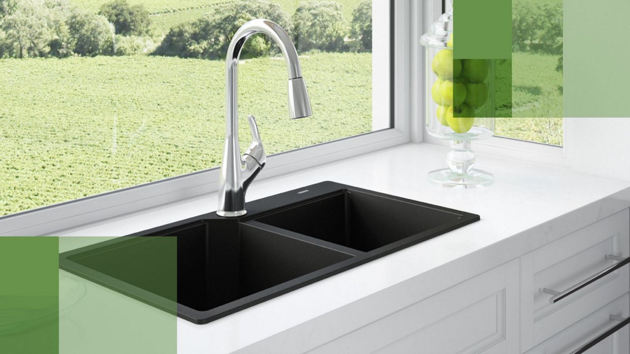 Kindred matte black double bowl granite kitchen sink with a chrome faucet in a white kitchen with large window 