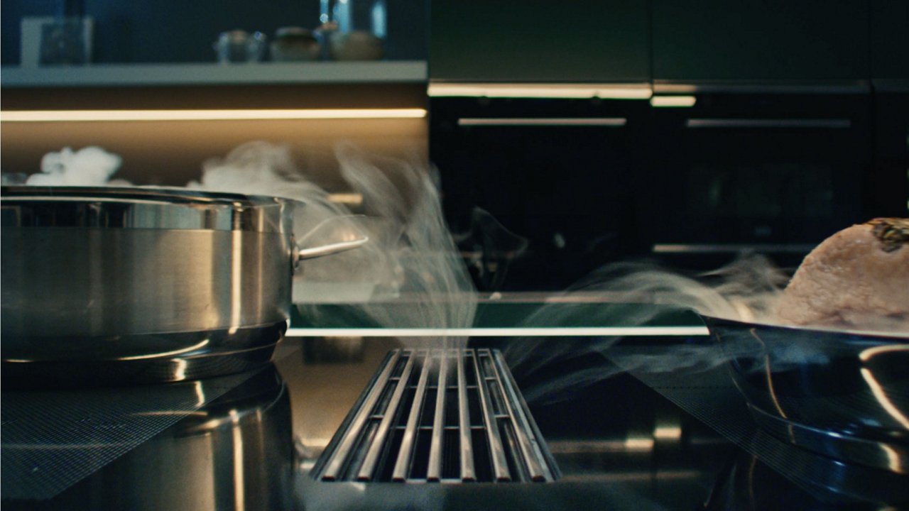 Cocina con tonos blancos y marrones y una columna de elecotrodomesticos 